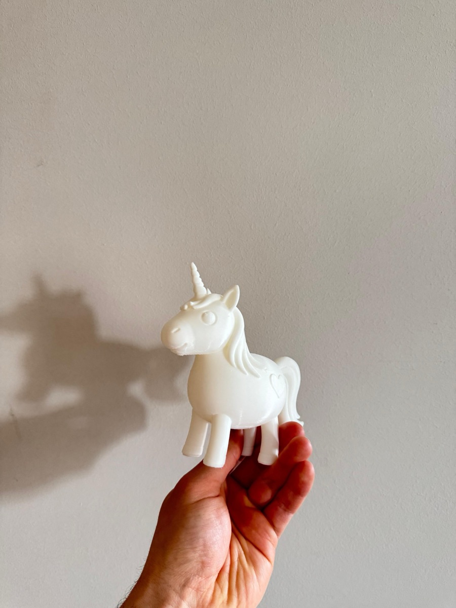 White unicorn figure in a hand